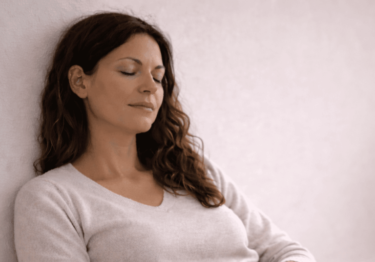 Mujer descansando con los ojos cerrados en un espacio tranquilo, sin culpa y regulación emocional
