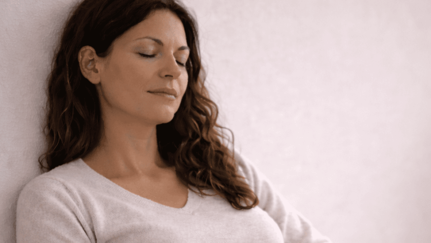 Mujer descansando con los ojos cerrados en un espacio tranquilo, sin culpa y regulación emocional