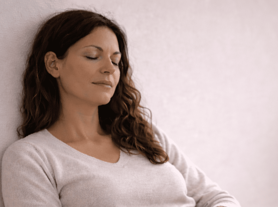 Mujer descansando con los ojos cerrados en un espacio tranquilo, sin culpa y regulación emocional